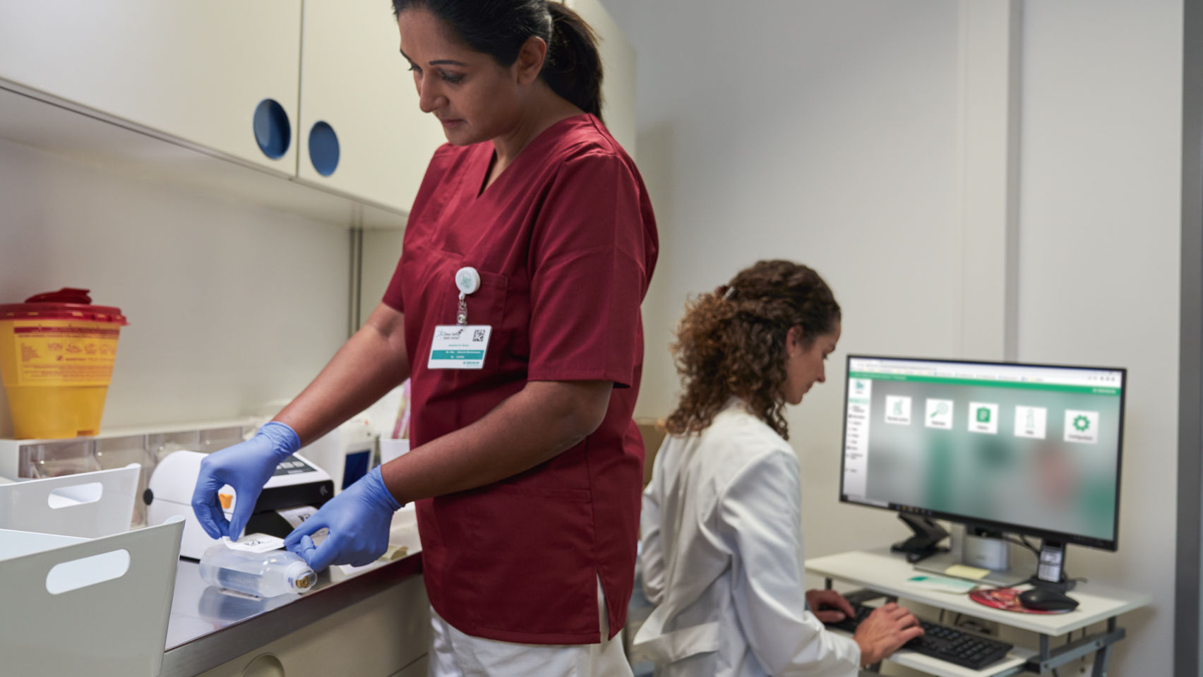 Oncology patient with glasses sitting on the chair and nurse with gloves handling cytoset 