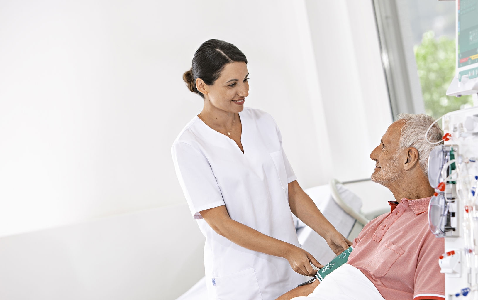 Pflegerin am Patientenbett Dialyse