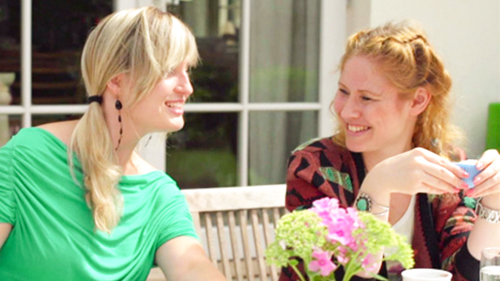 Two girl talking to each other and smiling